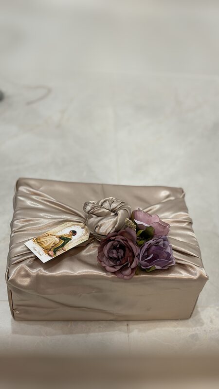 Gold satin wrapped gift with mauve roses